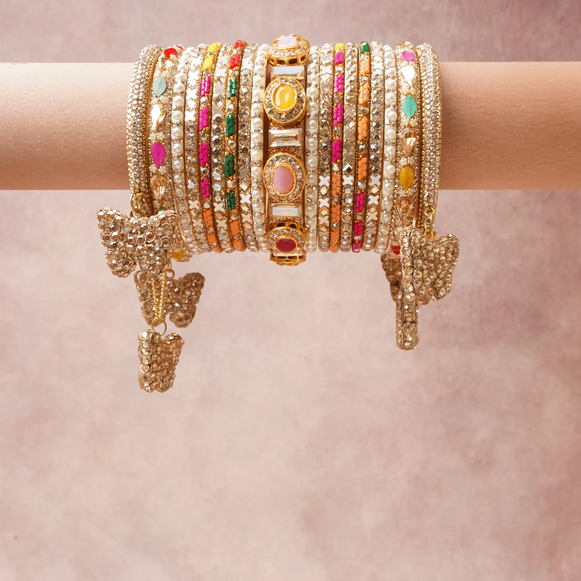 A commanding Multi colour anchors this beautiful set, enriched with accents of Fuchsia, Ruby Red, Emerald Green, Teal, Pale Pink, Canary Yellow, Clear, Orange that add depth and dimension.

Featuring a striking composition of Gold-toned metal, Cubic Zirconia, Pearls, Synthetic Ruby, Synthetic Emerald, Synthetic Yellow Sapphire, Synthetic Rose Quartz, Glass, Enamel, Resin, this set carries intricate craftsmanship and strong presence. Grand in form, it is created for moments that deserve to be marked.